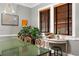 A bright dining room boasts windows with wood blinds, casting light onto the green table and seating arrangement at 93 Peachtree Ne Pl # 5, Atlanta, GA 30309
