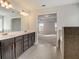 Modern bathroom featuring double vanity, gray tile flooring, and a view into the Main Bedroom at 508 Clayborne Way, Loganville, GA 30052