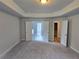 Large bedroom with trey ceiling, neutral carpet, and open doorway to the bathroom and closet at 508 Clayborne Way, Loganville, GA 30052