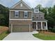 Two-story home features a brick and siding facade, attached garage, and a nicely manicured lawn at 508 Clayborne Way, Loganville, GA 30052