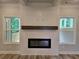 Modern fireplace with white wooden panels, dark wood mantle and windows that look out to the deck at 508 Clayborne Way, Loganville, GA 30052