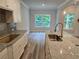 Kitchen view showcasing a large island, stainless steel faucet, hardwood floors, and window views at 508 Clayborne Way, Loganville, GA 30052