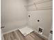 Compact laundry room with a single wire shelf, gray walls, and wood-look flooring at 508 Clayborne Way, Loganville, GA 30052