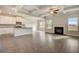 Open concept living area with hardwood floors, coffered ceilings, modern kitchen, and cozy fireplace at 508 Clayborne Way, Loganville, GA 30052