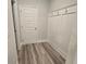 Hallway with a convenient coat rack, wood-look floors and a paneled white door at 508 Clayborne Way, Loganville, GA 30052