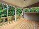 Back porch with wooden floors, railings and beams overlooking a beautiful backyard at 508 Clayborne Way, Loganville, GA 30052