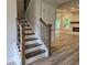 Wooden staircase with iron spindles leads to the upper level at 508 Clayborne Way, Loganville, GA 30052