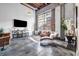 Modern living room featuring exposed brick, concrete floors, and large windows at 650 Glen Iris Ne Dr # 27, Atlanta, GA 30308