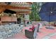 Outdoor kitchen featuring a stone fireplace, bar area, and comfortable seating for entertaining guests at 971 Hendon, Woodstock, GA 30188