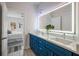 Modern bathroom featuring a double vanity with blue cabinets, quartz countertop, and a lighted mirror at 3165 Dogwood Dr # 106, Hapeville, GA 30354