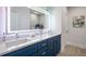 Modern bathroom featuring a double vanity with blue cabinets, quartz countertop, and a lighted mirror at 3165 Dogwood Dr # 106, Hapeville, GA 30354