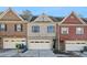 Townhome exterior with brick facade, attached garage, and well-maintained landscaping at 323 Sweetshrub Dr, Austell, GA 30168