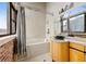 Bathroom with garden tub, exposed brick, window with city view, tiled wall, stone countertop with modern sink at 3235 Roswell Ne Rd # 917, Atlanta, GA 30305