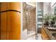 Elegant bathroom featuring shower with stone surround, glass door and shelving with granite countertop and towels at 3235 Roswell Ne Rd # 917, Atlanta, GA 30305