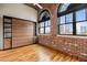 Bedroom boasts hardwood floors, exposed brick walls, and large windows offering city views at 3235 Roswell Ne Rd # 917, Atlanta, GA 30305