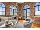 Bright living room with exposed brick walls, hardwood floors, a modern design, and city views at 3235 Roswell Ne Rd # 917, Atlanta, GA 30305