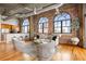 Open living room with exposed brick walls, hardwood floors, city views, and modern furnishings at 3235 Roswell Ne Rd # 917, Atlanta, GA 30305