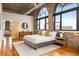 This main bedroom has views for days with large arched windows and exposed brick at 3235 Roswell Ne Rd # 917, Atlanta, GA 30305