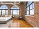 This bedroom shows off exposed brick, high ceilings, and hardwood floors at 3235 Roswell Ne Rd # 917, Atlanta, GA 30305