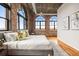 This main bedroom boasts lots of light with its massive arched windows and exposed brick walls at 3235 Roswell Ne Rd # 917, Atlanta, GA 30305