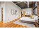 Large main bedroom with hardwood floors, exposed ductwork, and exposed brick at 3235 Roswell Ne Rd # 917, Atlanta, GA 30305