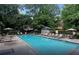 Outdoor pool with lounge chairs and umbrellas surrounded by lush landscaping at 3235 Roswell Ne Rd # 917, Atlanta, GA 30305