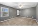 Empty bedroom with neutral carpet, ceiling fan and two bright windows at 3819 Trotters Run, Douglasville, GA 30135