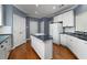 Charming kitchen featuring an island cooktop, white cabinets, and hardwood flooring at 3854 W Nancy Creek Ne Pl, Brookhaven, GA 30319