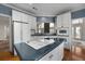 Cozy kitchen with white cabinets, blue walls, and island cooktop with black countertops at 3854 W Nancy Creek Ne Pl, Brookhaven, GA 30319