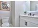 Modern half bathroom features white cabinets, marble countertop, black faucet, and framed artwork at 419 Mcinnes Se Cir, Marietta, GA 30060