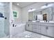 Bathroom featuring a tub, glass enclosed shower, marble tile, and gray cabinets at 419 Mcinnes Se Cir, Marietta, GA 30060