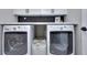 Modern laundry room with sleek black and white machines and stylish backsplash at 419 Mcinnes Se Cir, Marietta, GA 30060