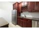 Basement bar featuring stainless appliances, dark wood cabinets, granite counters, and a wine rack at 5715 Catalpa Ct, Cumming, GA 30040