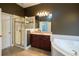 Bathroom featuring a glass shower, large soaking tub, and vanity with sink at 5715 Catalpa Ct, Cumming, GA 30040