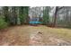 View of backyard with some fallen tree limbs; the house is partially visible and tarped at 1969 Oak Valley Rd, Decatur, GA 30035