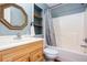 Cozy bathroom featuring a shower-tub combo and a wooden vanity with a mirror and shelves at 2370 Huckleberry Ln, Lithia Springs, GA 30122