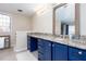 Bathroom with a granite countertop and dark blue cabinets, with natural light from a stained-glass window at 2370 Huckleberry Ln, Lithia Springs, GA 30122