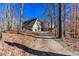 Multi-level home features a unique roofline, private driveway, and multiple windows surrounded by mature trees at 2370 Huckleberry Ln, Lithia Springs, GA 30122