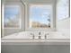 Close-up of a luxurious bathtub with chrome fixtures and a bright window view at 3916 Woodruff Park Way, Buford, GA 30519