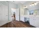 Bathroom featuring double sinks, white cabinetry, and wood-look floors at 3916 Woodruff Park Way, Buford, GA 30519