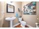 Cozy half bath featuring a pedestal sink, decorative floral painting, and neutral paint at 3916 Woodruff Park Way, Buford, GA 30519