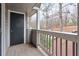 Balcony with gray wooden floors and railing offers serene views of the surrounding nature at 128 Warm Springs Cir, Roswell, GA 30075