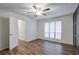 This bedroom has hardwood floors, a window with neutral blinds, and an open door at 128 Warm Springs Cir, Roswell, GA 30075