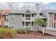 Inviting condominium exterior with neutral siding, balconies, and charming landscaping offering a welcoming curb appeal at 128 Warm Springs Cir, Roswell, GA 30075