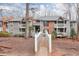 Multi-level condo complex with brick and gray siding, featuring charming balconies and lush landscaping at 128 Warm Springs Cir, Roswell, GA 30075