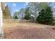 Paved backyard with a privacy fence, large trees, and wooden deck at 2030 Brook Meadow Dr, Alpharetta, GA 30005