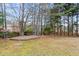 Wooded backyard view featuring healthy grass, landscaping and a brick-lined flowerbed at 2030 Brook Meadow Dr, Alpharetta, GA 30005