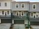 View of three townhomes with dark garages, balconies with outdoor seating, and gray siding at 3165 Dogwood Dr # 108, Hapeville, GA 30354