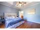 Serene main bedroom with tray ceiling, large windows, hardwood flooring, and view to ensuite bathroom at 1063 Emerson Avenue Se, Atlanta, GA 30316