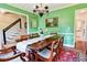 Dining room with green walls, hardwood floors, and view into the kitchen and stairway at 566 Wagon Wheel Climb, Lawrenceville, GA 30044